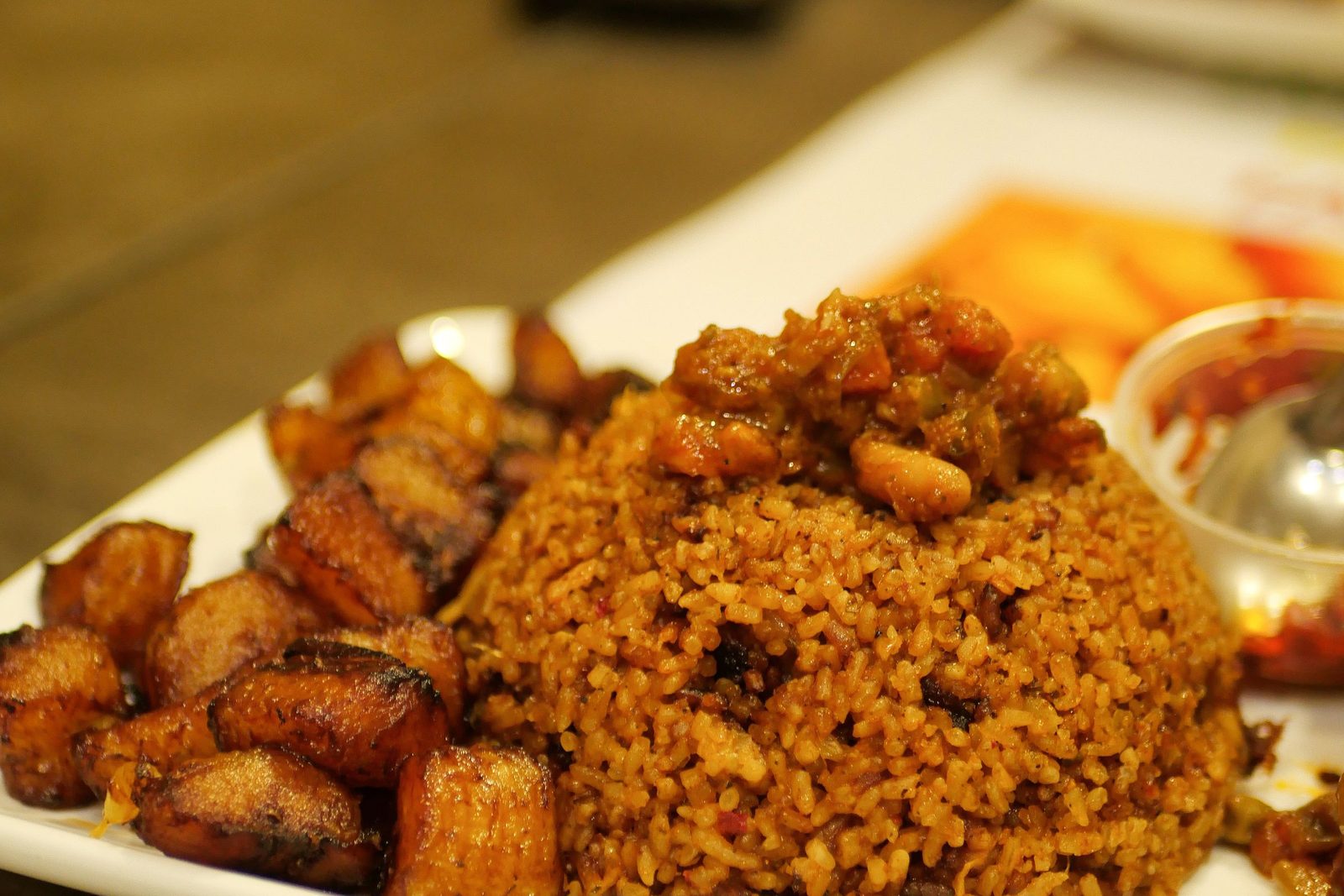 Mittagsteller mit Jollof Reis und gebratenen Kochbananen
